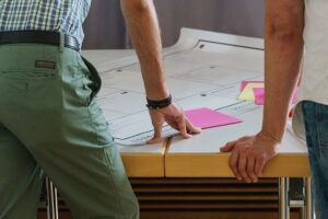 A picture of a workshop taking place with post-it notes on a table.