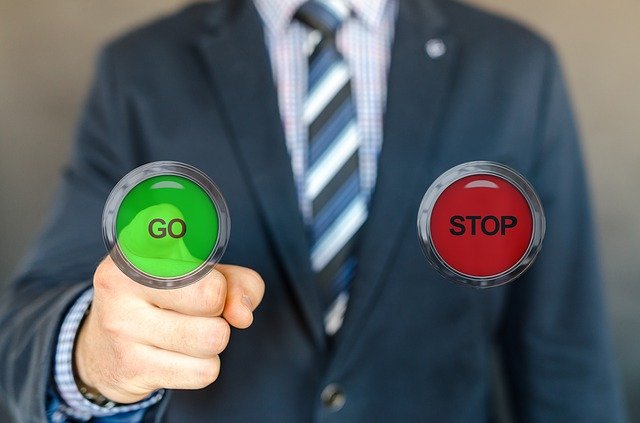 An image of someone pressing a button marked go rather than a button marked stop.