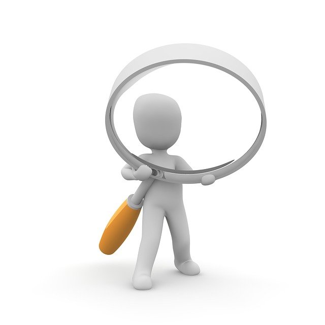 An image of a person holding a giant magnifying glass. A tool like this might help when conducting an operational review!